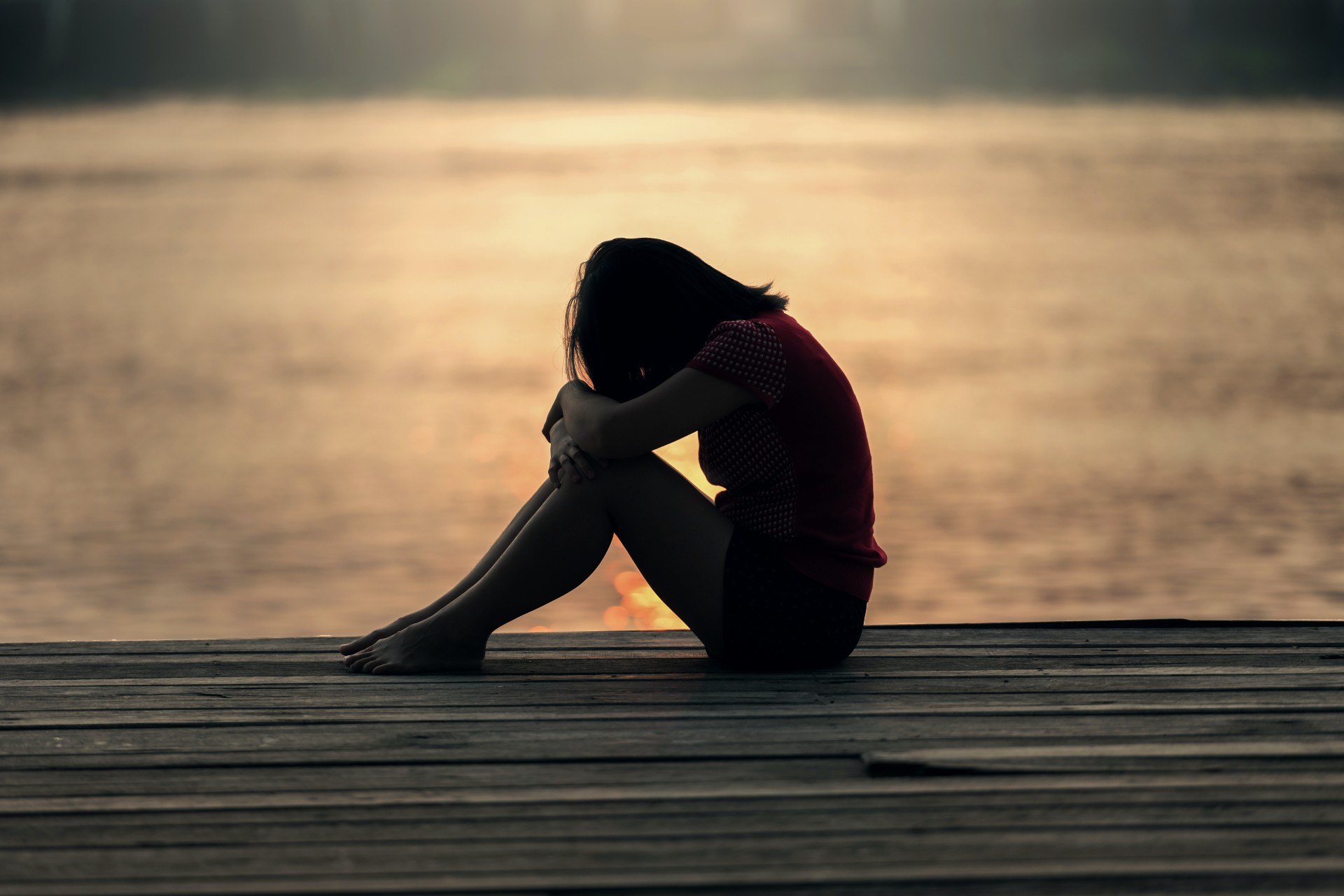 Sad woman by lake