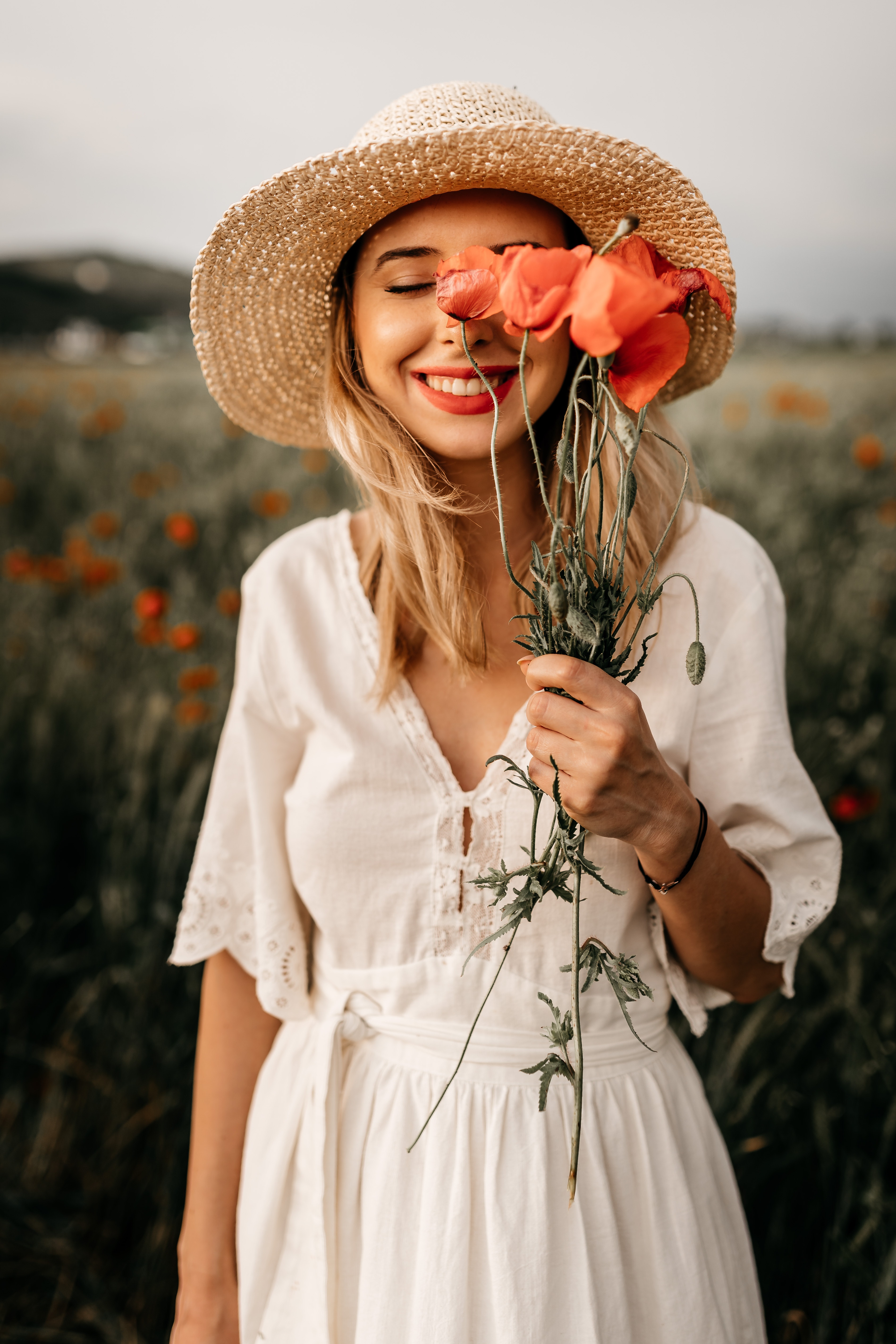 Woman in hat holding flowers